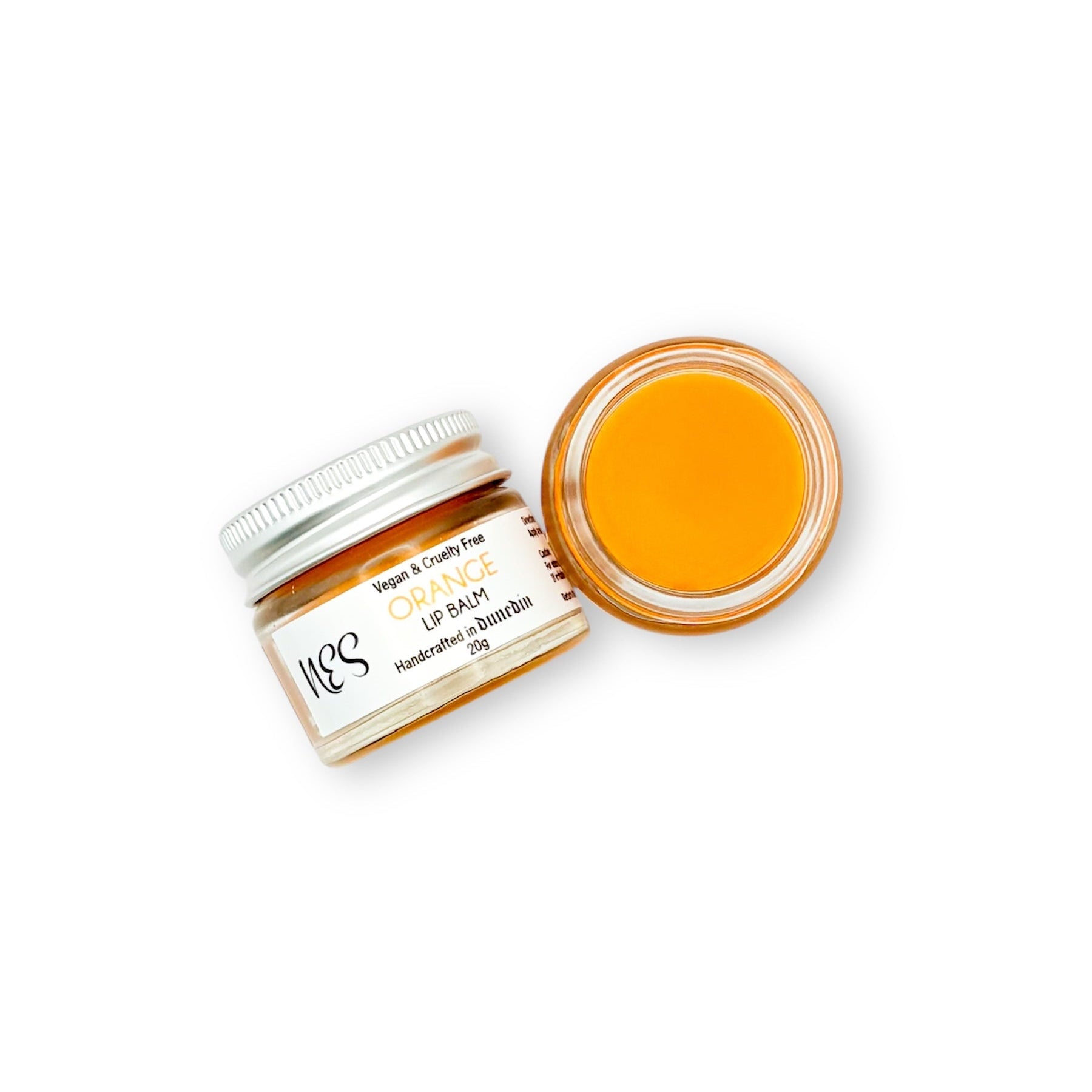 Open jar of NES Orange Lip Balm with a smooth, citrus-infused formula. Vegan, cruelty-free, and perfect for hydrated lips.