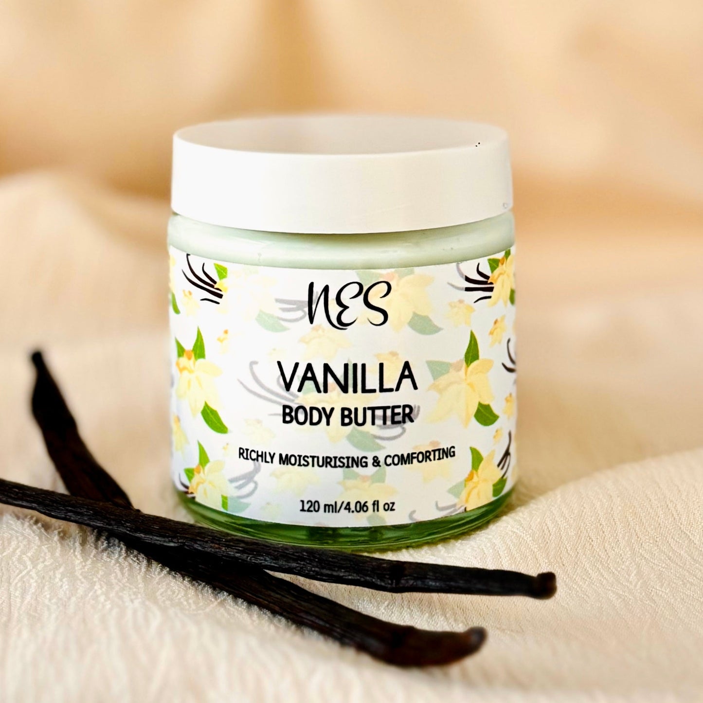 Vanilla body butter by NES Soap with vanilla pod on top of a soft cream coloured fabric. Ethical, vegan skincare handmade in Dunedin, New Zealand.