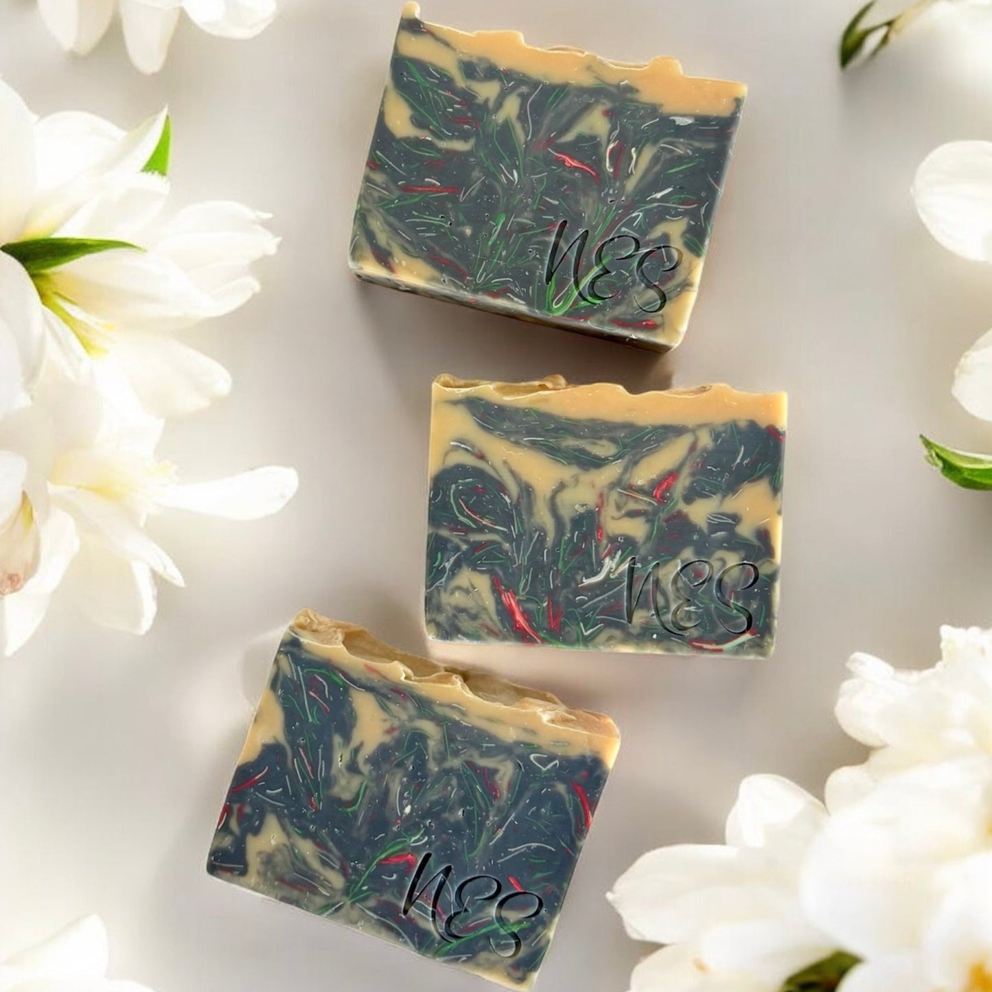 NES Midnight Bloom artisan soap bar surrounded by white flowers - scented with bergamot, gardenia, jasmine and sandalwood.