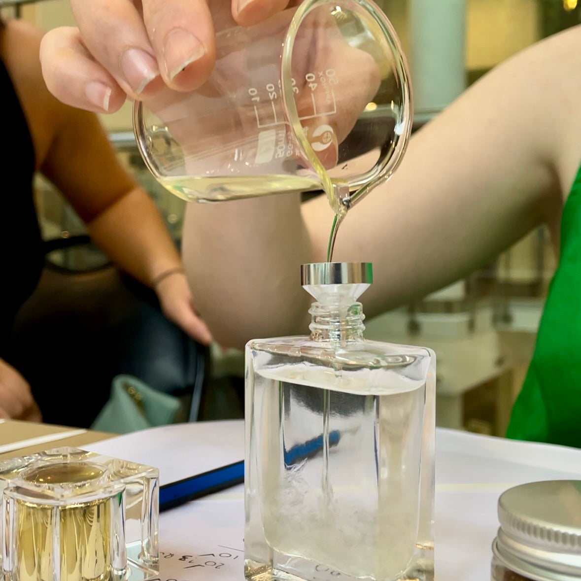 Pouring perfume into a perfume bottle at NES perfume making workshop at GUILD Dunedin, NZ.