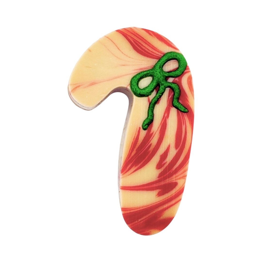Decorative candy cane soap with red and white swirls and a green bow on a white background. Vegan and cruelty free soap, handmade in Dunedin, NZ by NES Soap