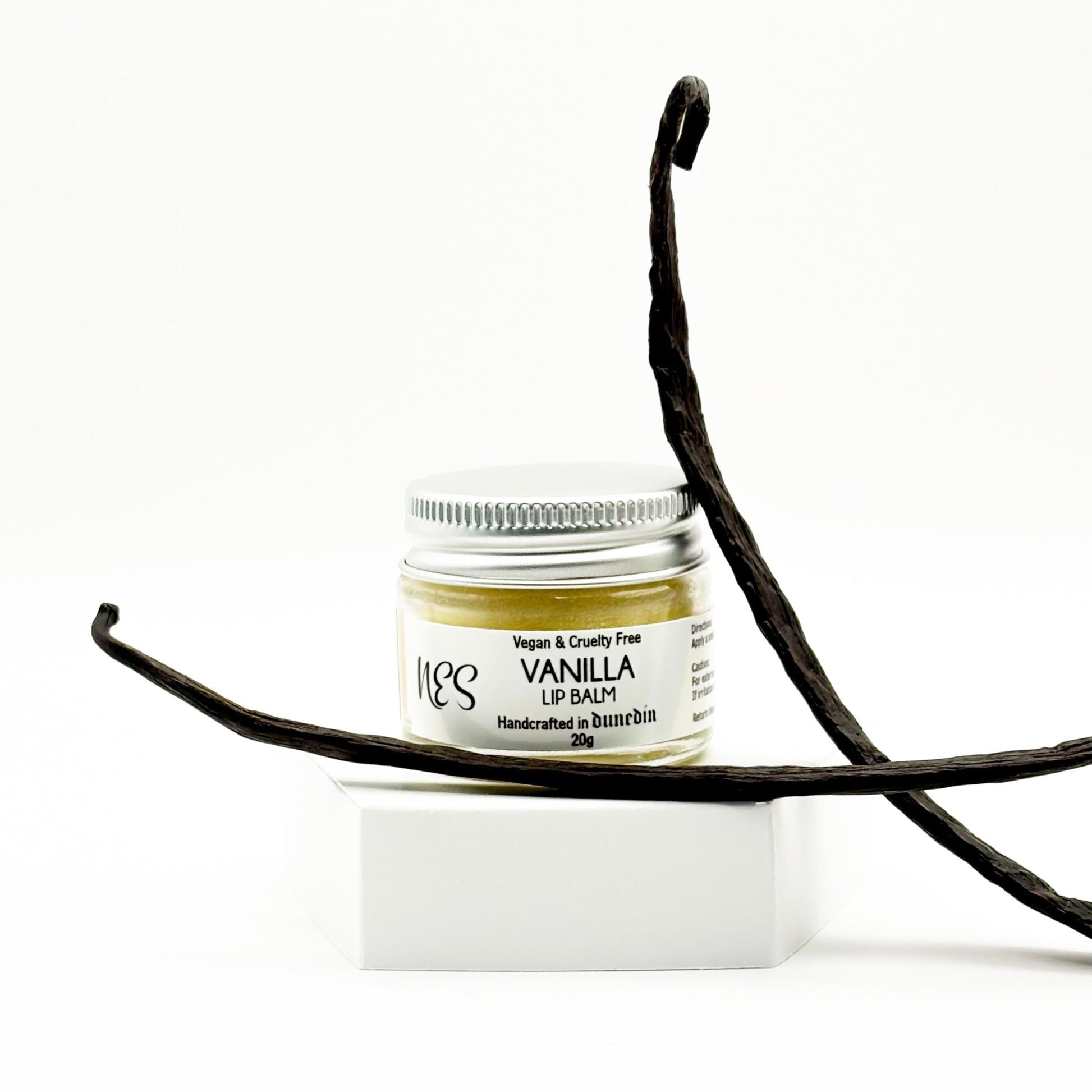 NES Soap vanilla lip balms in glass jars, between two vanilla pods, eco-friendly and vegan skincare made in Dunedin, New Zealand.