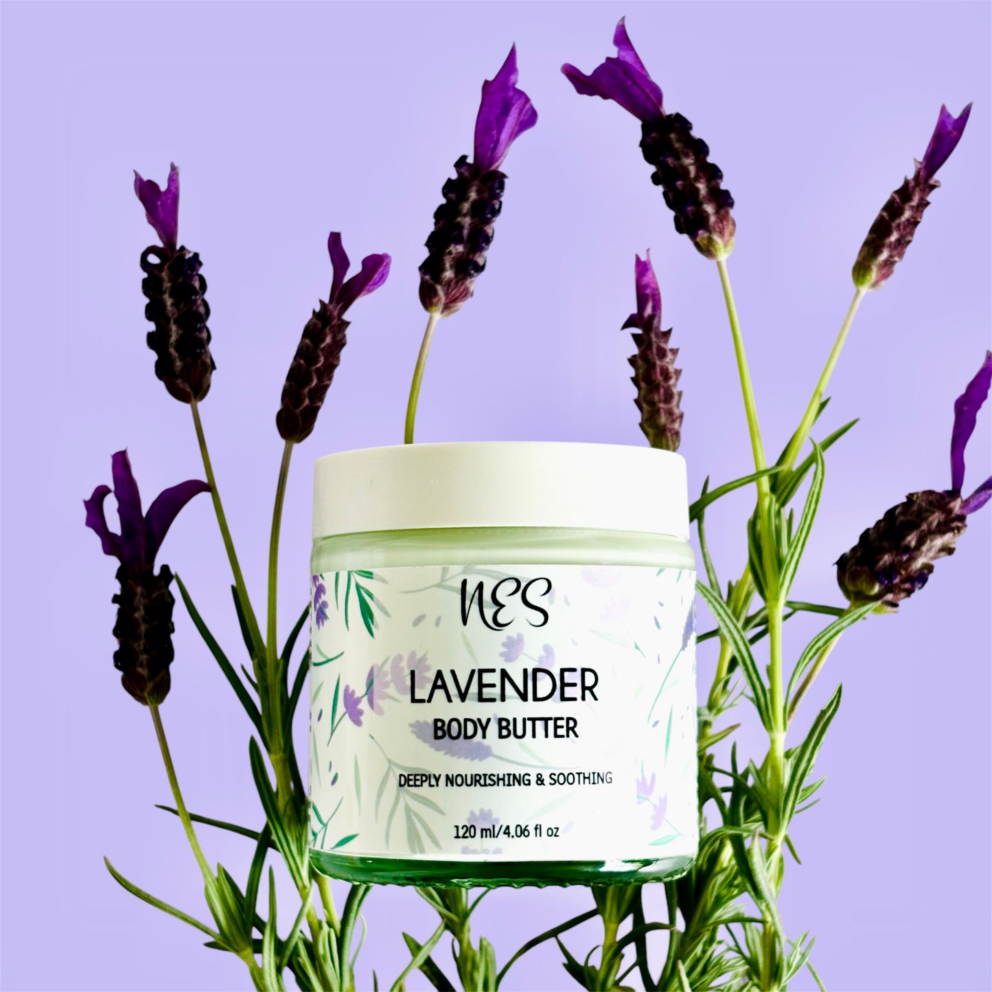 NES Lavender Body Butter in a glass jar, surrounded by fresh lavender flowers. Vegan, deeply hydrating skincare made with shea butter and vitamin E – NES Soap NZ.